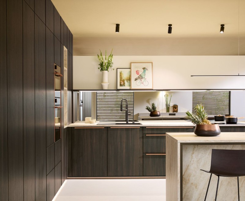 Conception d'une cuisine élégante en bois foncé avec profilés cuivrés et crédence miroir, une réalisation exclusive de NA Concept à Mauléon-Licharre.